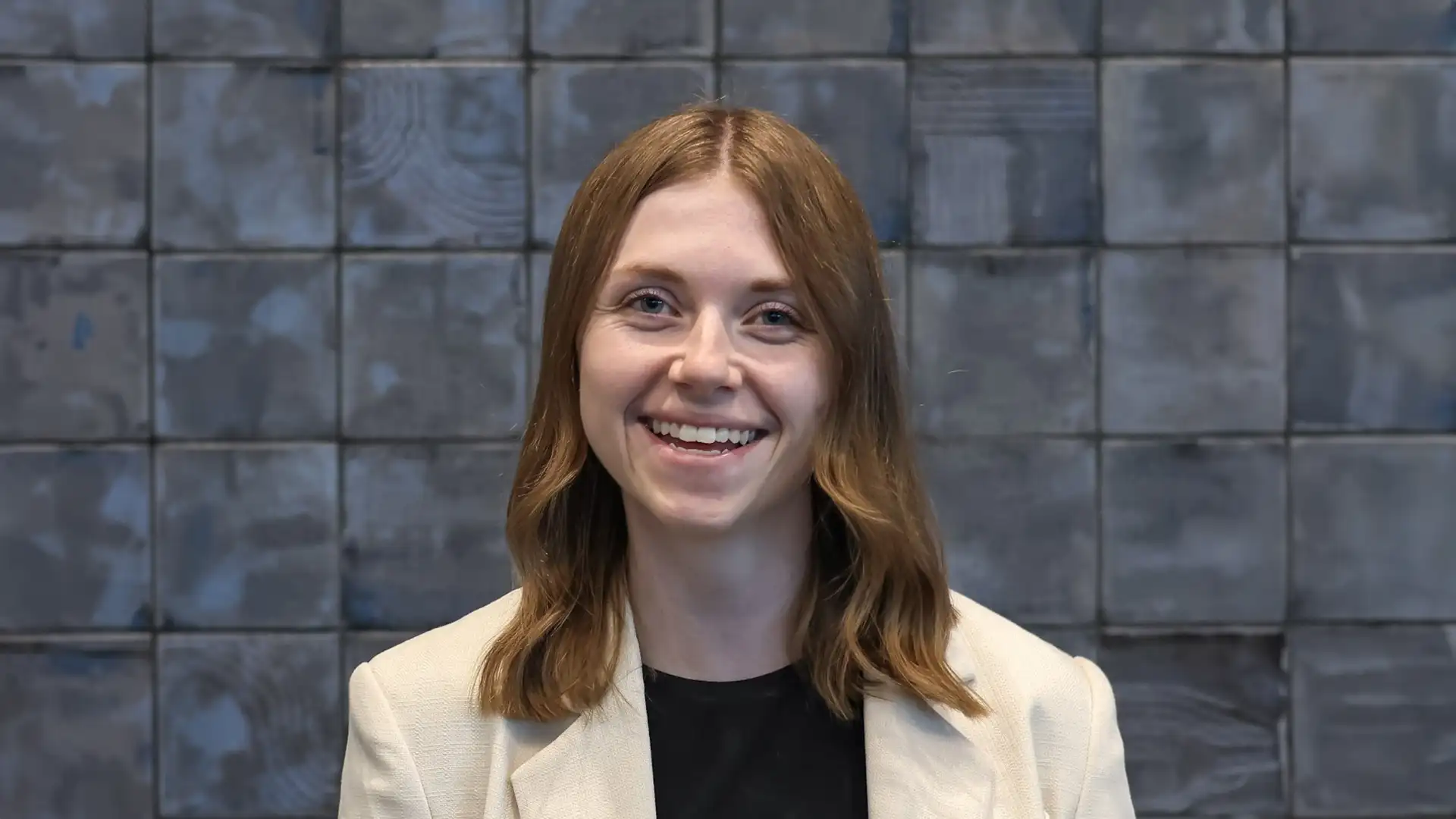 Larissa Markewich smiling in front of a patterned wall